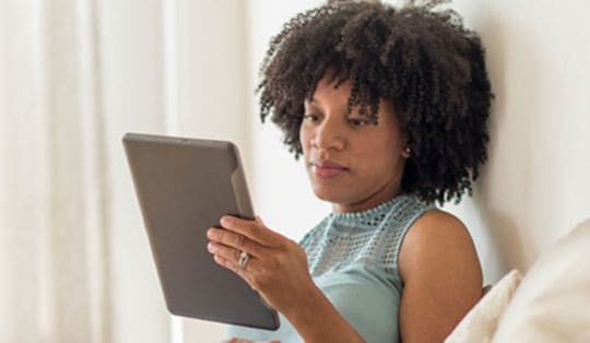 Woman reads on her tablet.